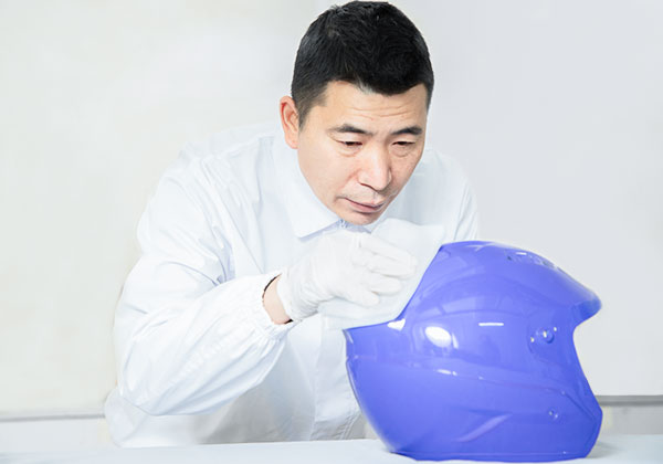 worker wiping helmet with sustainable paint